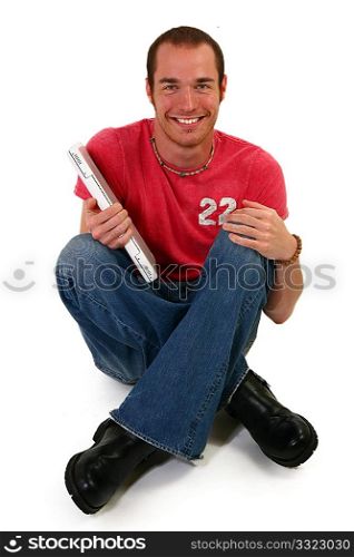 Man on floor with laptop smiling.