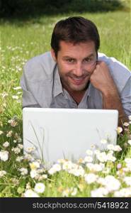 Man on laptop in field