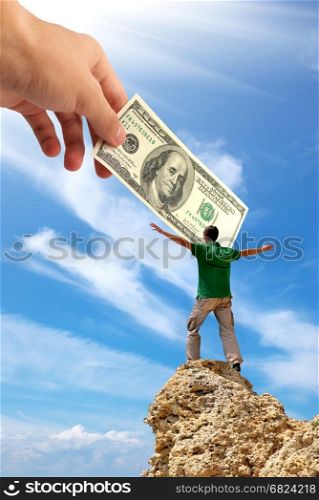 Man on peak of mountain and hand with money. Money conception design.