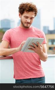 Man On Roof Terrace Using Digital Tablet