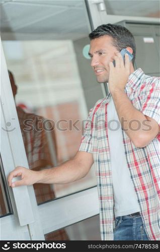 Man on telephone, holding door handle
