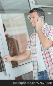 Man on telephone, holding door handle