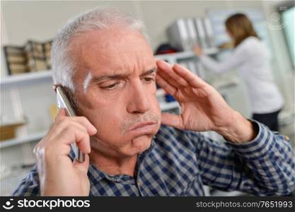 Man on telephone, looking stressed