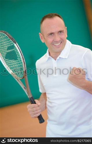 Man on tennis court making victory gesture