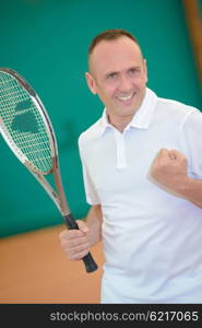 Man on tennis court making victory gesture