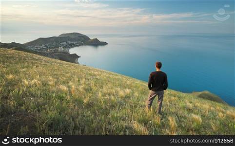 Man on the edge. Cliff of mountain and sea. Conceptual scene.
