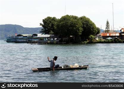 Man on the fishing boat near Samosir island, Indonesia