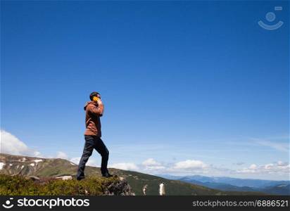 Man on the mountain top talking by cell phone