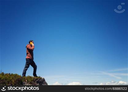 Man on the mountain top talking by cell phone
