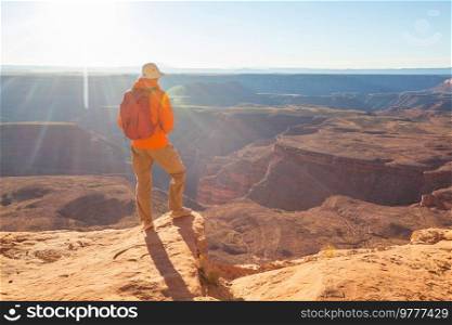 Man on the mountains cliff at sunrise. Hiking scene.