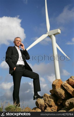 Man on the phone in front of the windmill