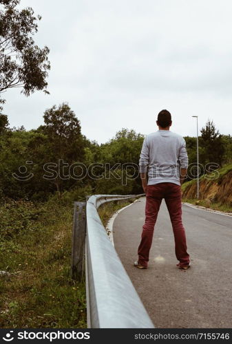 man on the road walking to the mountain feeling the nature, peace and freedom