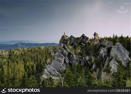 man on the top of the forest rock