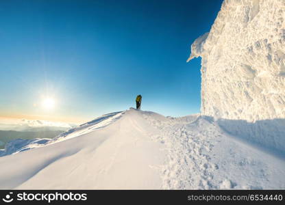 Man on the top of the winter mountain in snow at sunset. Man on the top of the winter mountain