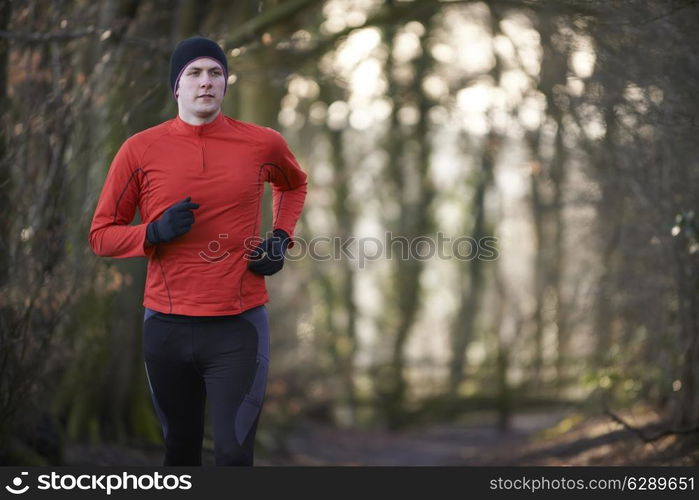 Man On Winter Run Through Woodland