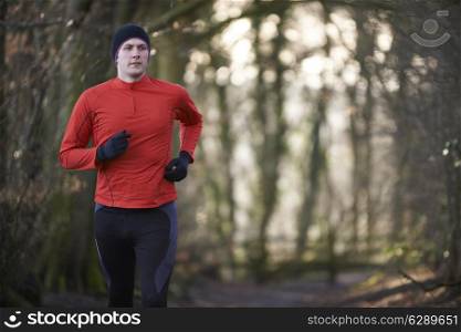 Man On Winter Run Through Woodland