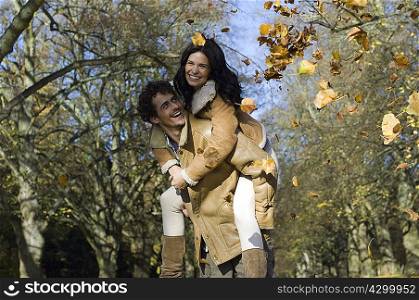 Man on woman&acute;s back with leaves