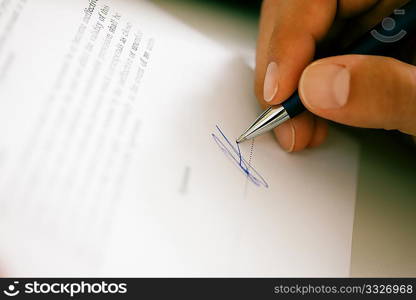 Man (only hand to be seen) signing a contract or another document (fake signature)