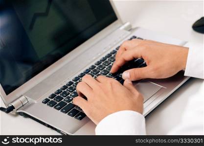 Man (only hand to be seen) using a computer keyboard typing, working on a presentation