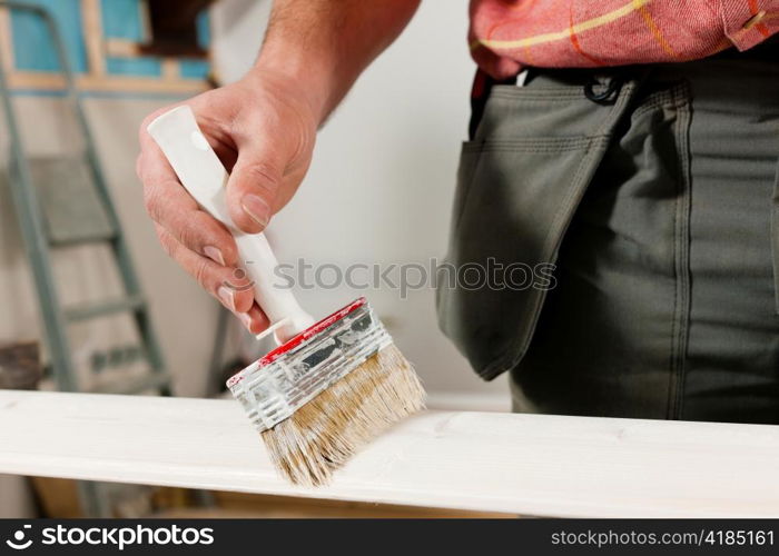 Man - only hands to be seen - is painting in his house; presumably he is renovating