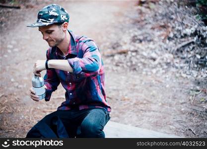 Man opening bottled water, Big Sur, California, USA