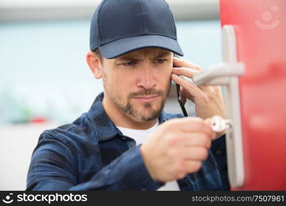 man opening door lock with lockpicker