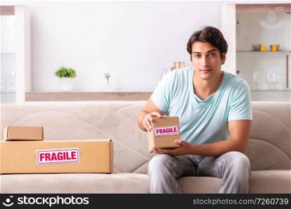Man opening fragile parcel ordered from internet. The man opening fragile parcel ordered from internet