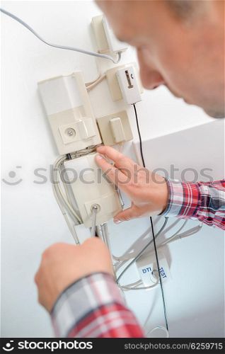 Man opening fusebox hatch with screwdriver