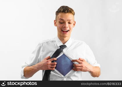 man opening his shirt . Teenager is opening his shirt to reveal blue tee like super hero