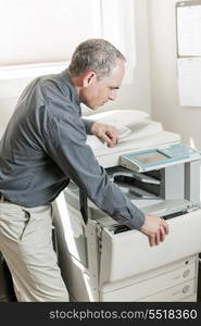 Man opening photocopier in office. Business man opening photocopy machine in office