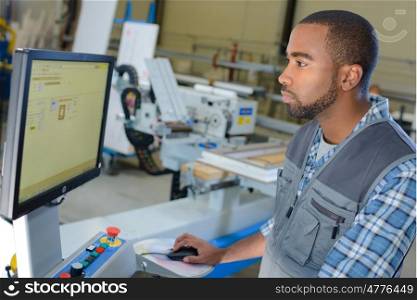 Man operating computer in industrial setting