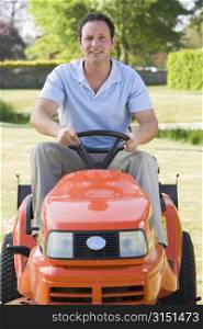 Man outdoors driving lawnmower smiling