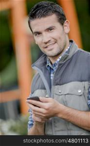 Man outdoors holding mobile telephone