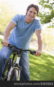 Man outdoors on bike smiling