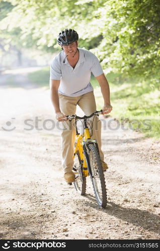 Man outdoors riding bike smiling