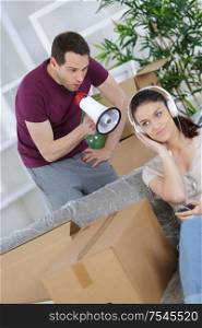 man packing moving boxes and his lazy girlfriend