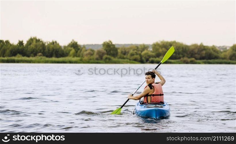 man paddle kayaking lake looking back