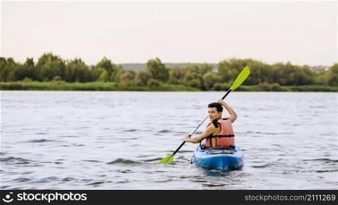 man paddle kayaking lake looking back