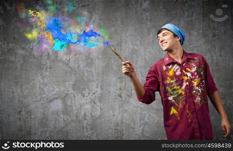 Man painter. Young handsome man painter with brush in hand
