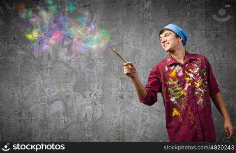 Man painter. Young handsome man painter with brush in hand