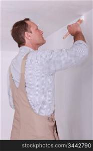 Man painting a room white