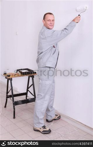 Man painting an interior wall white