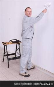 Man painting an interior wall white