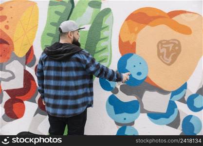 man painting graffiti wall