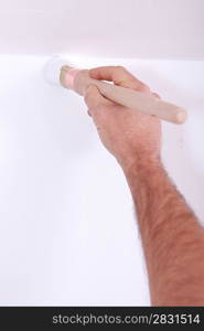 Man painting wall with brush
