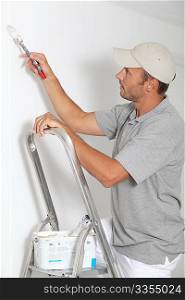 Man painting walls in white