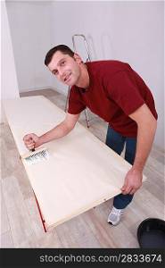 Man painting wooden plank