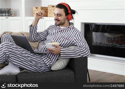 man pajamas eating popcorn