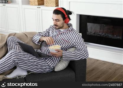 man pajamas eating popcorn high view