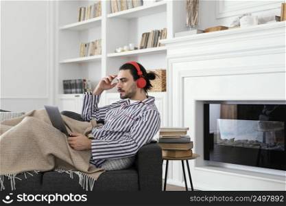 man pajamas using laptop indoors